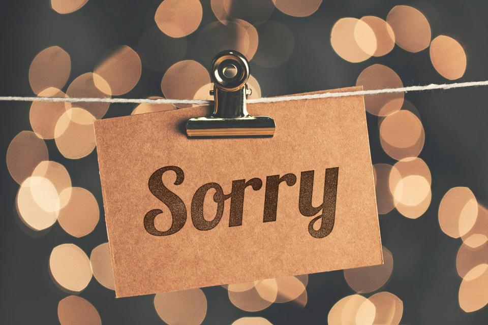Sorry sign pegged to a string with blurred bokeh lights in the background