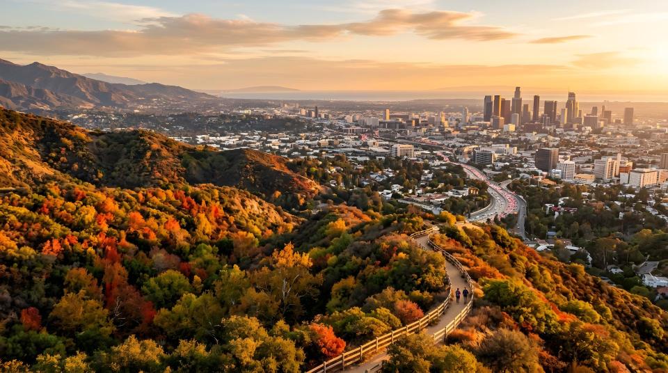 Scenic golden hour view of a city skyline from mountain hiking trails during autumn sunset