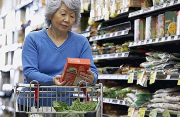 Woman reviewing healthy food options in grocery aisle