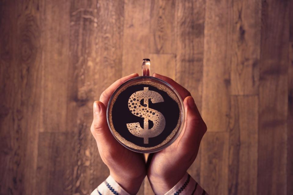Cup of Coffee on Wooden Surface with Loose Change