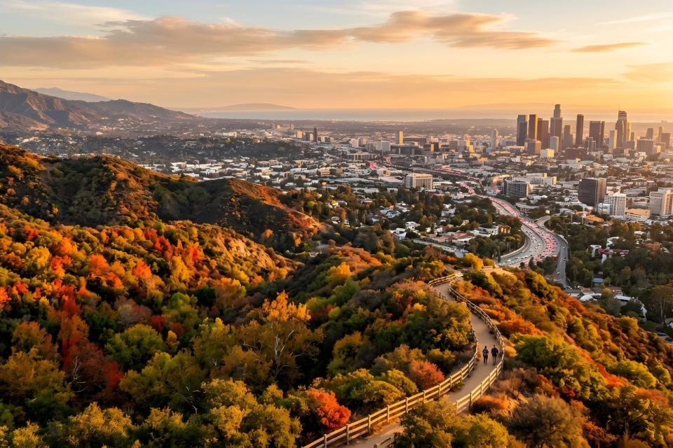Scenic golden hour view of a city skyline from mountain hiking trails during autumn sunset