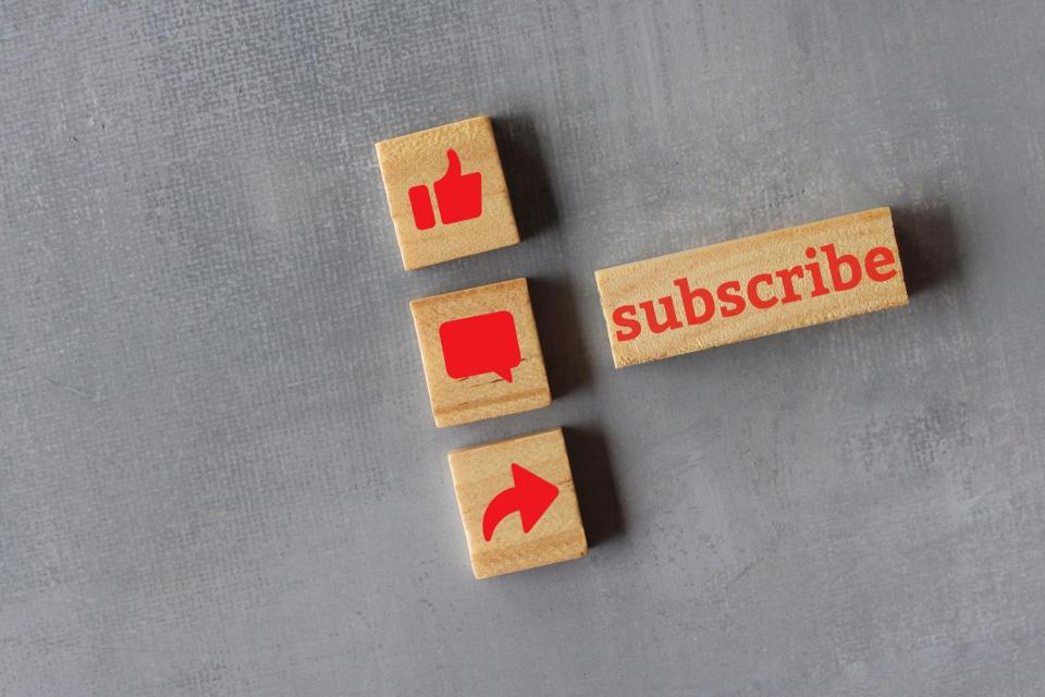 Technology and media social concept. Top view of wooden cubes with text SUBSCRIBE and like, comment and share icon.