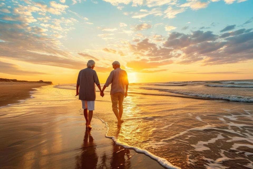 Couple walking next to the shoreline during sunset.