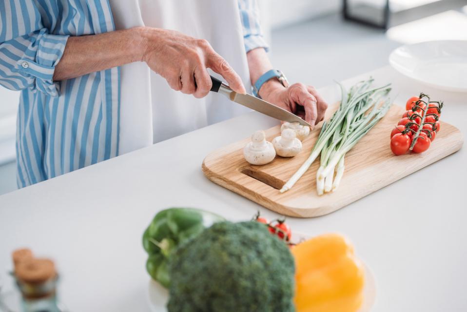 Hands chopping vegetables in a kitchen