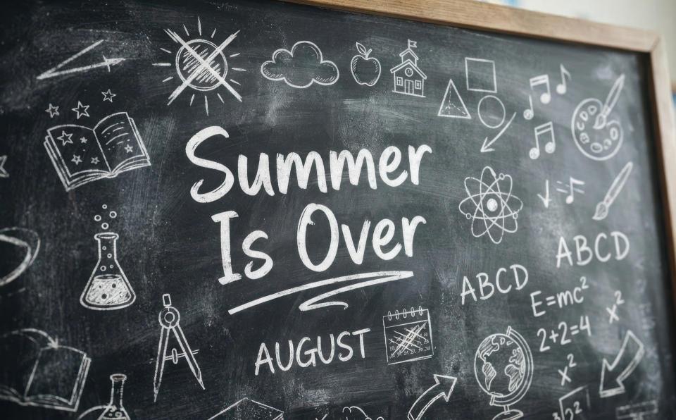 Black board with multiple drawn school supplies, with Summer is Over in the middle and August right below it.