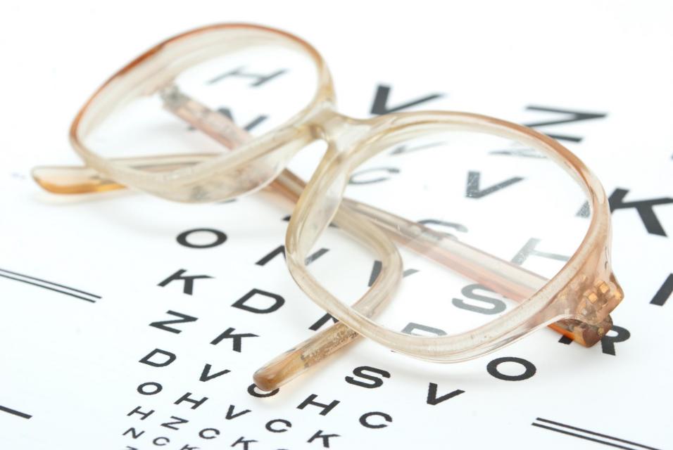 Glasses with eye chart isolated on white.