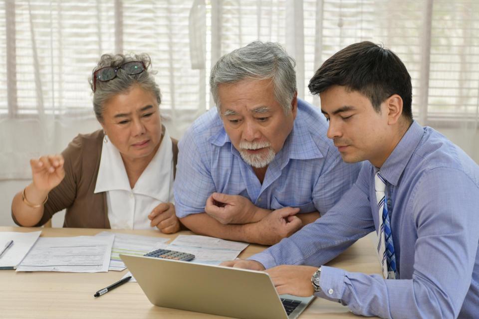 Senior couple discussing finances with tax advisor.
