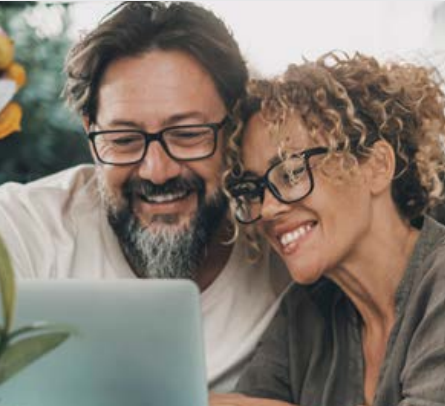Couple smiling in front of computer